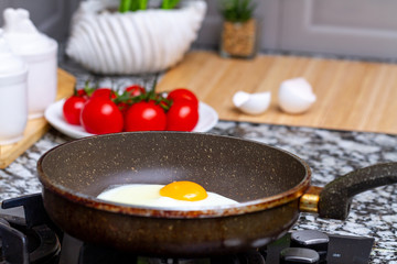 Frying homemade, chicken eggs in the frying pan at kitchen at home. Cooking a healthy, protein breakfast