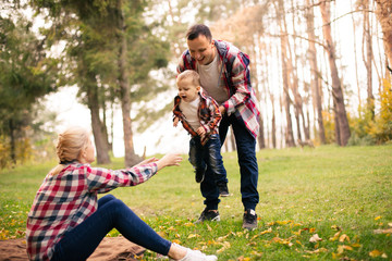 Little cute son playing with parents in forest