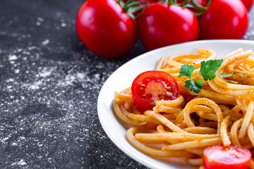 Delicious, homemade pasta with tomato sauce, parsley, spices and vegetables on a plate. Italian food