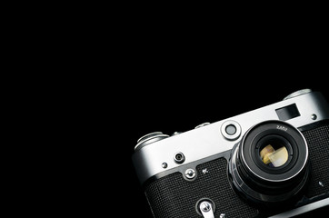 Old vintage shiny film camera on black background isolated, high contrast