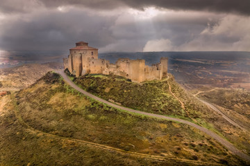 Fototapeta na wymiar Aerial view of the ruined medieval abandoned Montearagon castle, namesake of the famous kingdom on a bare mountain top near Huesca, Aragon province Spain with stormy cloudy sky