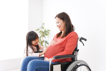 妊娠した女性とお腹に耳をあてる子ども
