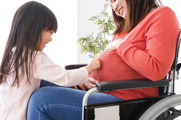 妊娠した女性とお腹に耳をあてる子ども