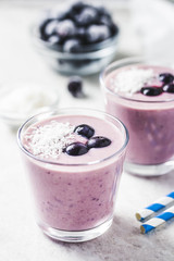 Frozen berries banana smoothie with coconut flakes. Selective focus, space for text.