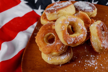 Close up of delicious lush donuts with top over american flag background