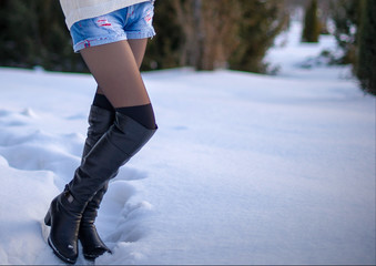 girl in shorts and boots in the snow.