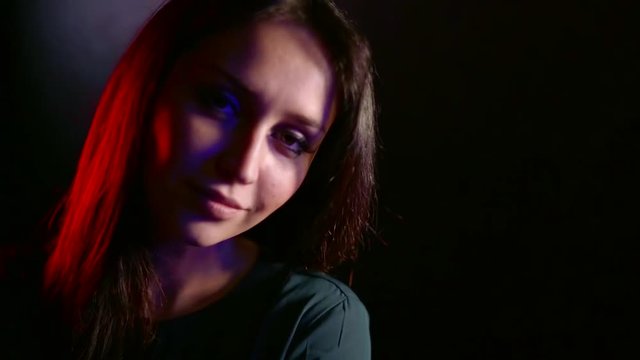 alone alluring woman is looking at camera tempting, shadows and lights on her pretty face