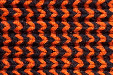 Knitting. Background knitted texture. Bright knitting needles. Orange and black wool yarn for knitting.