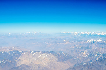 Naklejka premium Mountains earth from aircraft under blue sky