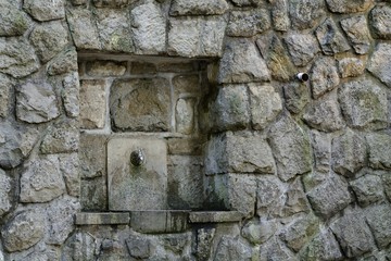 Stone wall with a splash of drinking water. Hostyn. East Moravia. Czech Republic. Europe.