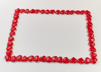 frame lined from small glass hearts on a white background. Valentine's Day. Love symbol. copy space