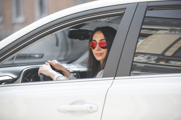 Naklejka premium Confident woman in automobile. Lady driving a car. Young beautiful female sitting in the auto. Urban woman.