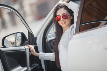 Confident woman in automobile. Lady driving a car. Young beautiful female sitting in the auto. Urban woman.