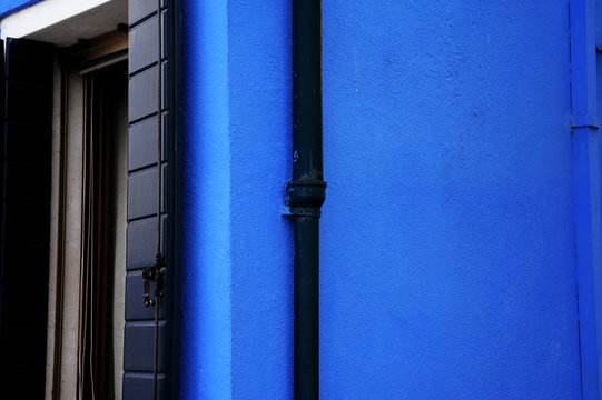 Black Pipe On A Blue House Wall In Colorful Burano