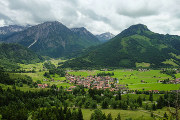 idyllic mountain landscape with a small village and mountains in the background