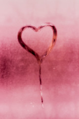 Figure heart on the glass. The texture of misted glass. Drops on the glass. Bright pink color picture. Valentine's Day