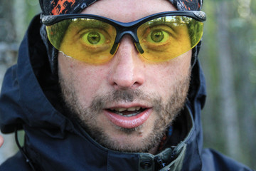 Portrait of a white Caucasian man with bristles surprised and shocked in bright yellow glasses