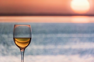 Glass of Chardonnay White Wine overlooking the sea during the sunset