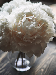 bouquet of white peonies in a vase on the wooden table