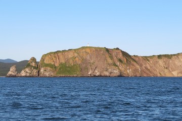 Fototapeta na wymiar View of the coastal cliffs of the Kamchatka Peninsula, Russia. The Kamchatka peninsula contains the volcanoes of Kamchatka, a UNESCO World Heritage Site.