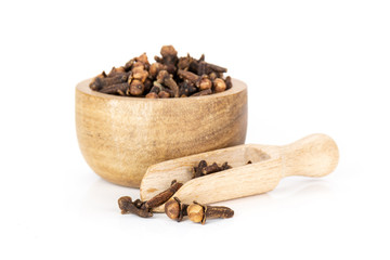 Lot of whole small dried cloves spice scoop with wooden bowl isolated on white background