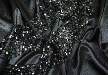 soft folds of black shiny fabric with sequins