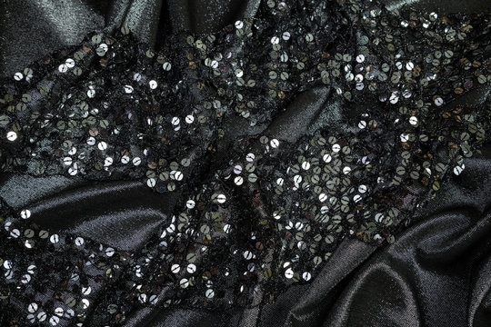 soft folds of black shiny fabric with sequins