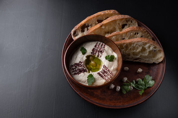 Hummus in pottery, on a dark background