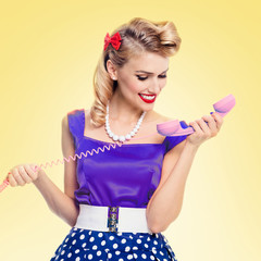 smiling woman with phone, dressed in pinup style