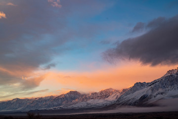 Obraz na płótnie Canvas pink sky clouds over snowy mountain range at sunrise