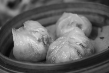 Three dim sum steam dumplings in a wooden cooking basket in Hong Kong