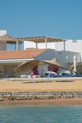 Villa by the sea. Beach with umbrellas at the luxury villa. vertical photo.
