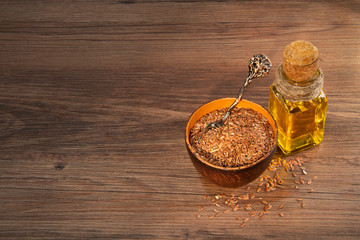 Flax seeds and oil on wooden table