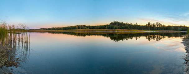 Lake with vegetation on the shore panoramic view