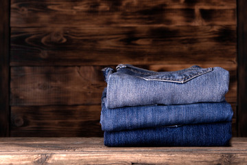 stack of jeans on wooden background