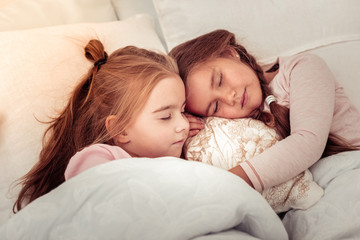 Two cute red haired girls sleeping together