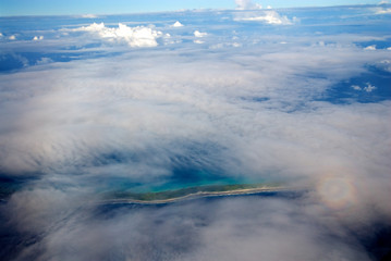 Aerial view of an Atoll island in the Pacific Ocean under clouds