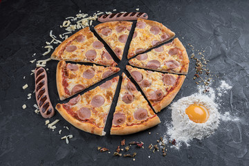 Tasty pizza with sausage on black background