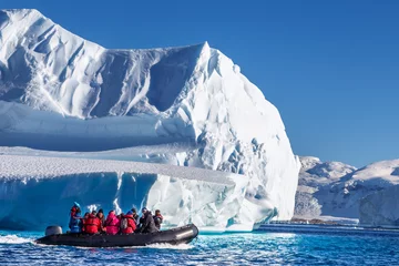 Printed roller blinds Antarctica Tourists sitting on zodiac boat, exploring huge icebergs driftin