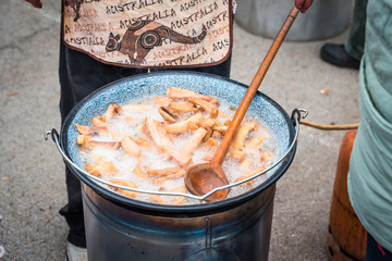 fresh traditional pork cracklings are cooked in the cauldron outside
