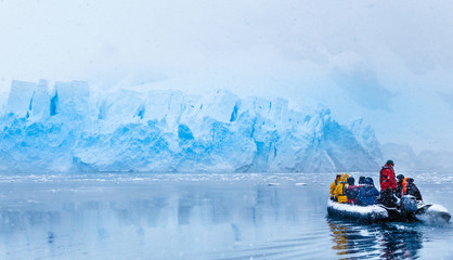 Snowfall over the boat with frozen tourists driving towards the