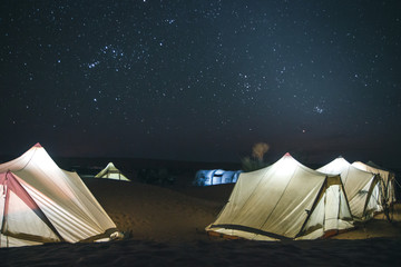 Amazing adventure trip in the Sahara desert, tent camp among the dunes under starry sky