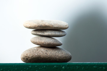 Closeup of stone balance on metallic fence in border river