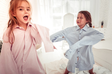Cheerful nice girls standing on the bed