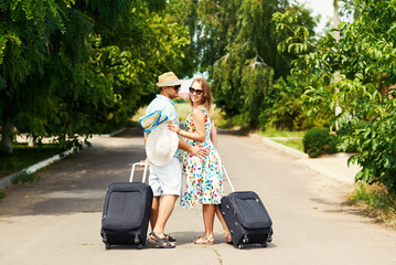 Romantic couple on way in airport. Attractive young woman and handsome man with suitcases are ready for summer traveling.