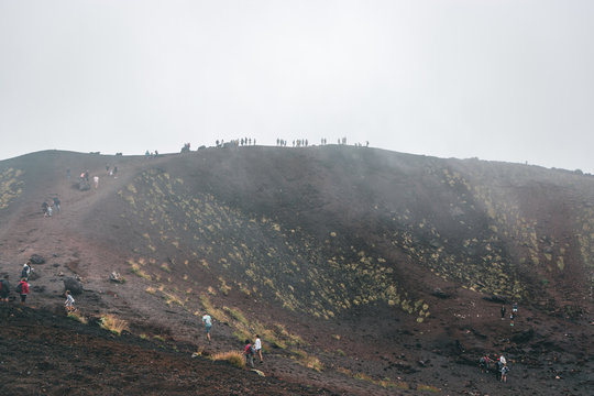 Excursion in the Silvestri crater, Volcano Etna and people in the fogh