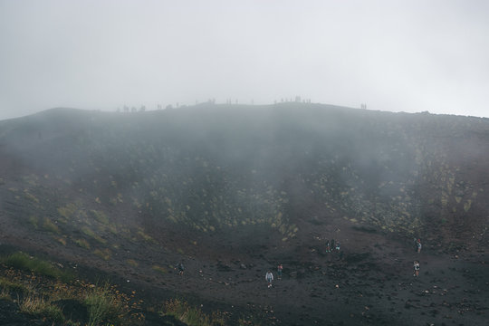 Excursion in the Silvestri crater, Volcano Etna and people in the fogh