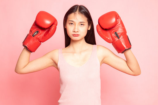 Young Asian woman with red boxing gloves.