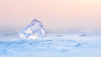 Ice on the frozen lake at sunset. Shallow depth of field. Beautiful winter background