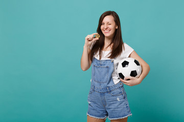 Blinking joyful young woman football fan support favorite team with soccer ball, bitcoin future currency isolated on blue turquoise background. People emotions, sport family leisure lifestyle concept.